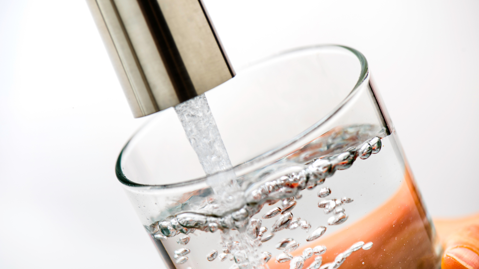 filling glass of water from faucet