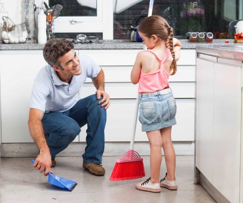 father and daughter sweeping the floor
